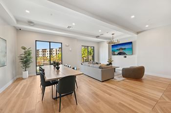 A modern living room with a wooden floor and a large window. at The Concord Luxury Apartments, Sarasota, Florida